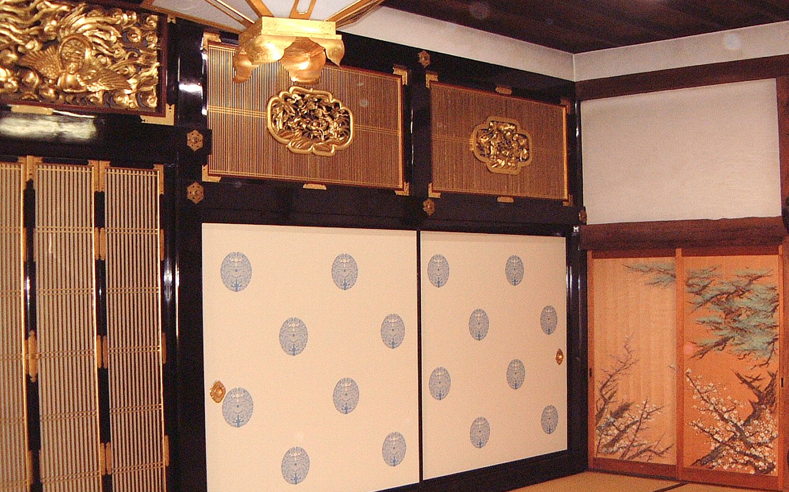 金箔の彫刻や装飾が施された和室の内部、襖や欄間が美しく仕上げられた室内の様子